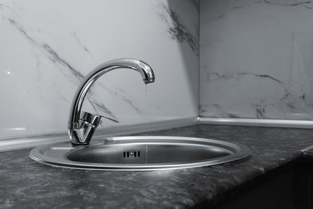 A clean and modern kitchen sink with a chrome faucet, highlighting minimalist design and water conservation.